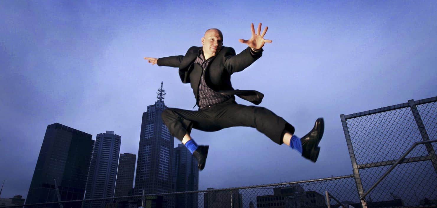 Executive leaping in front of city buildings